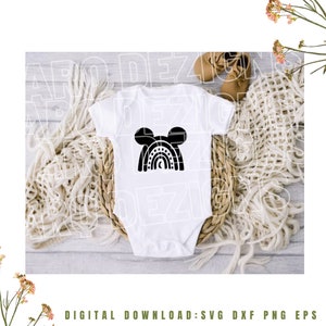 May include: A white baby onesie with a black silhouette of a rainbow with Mickey Mouse ears on top. The rainbow has stars and a moon inside.