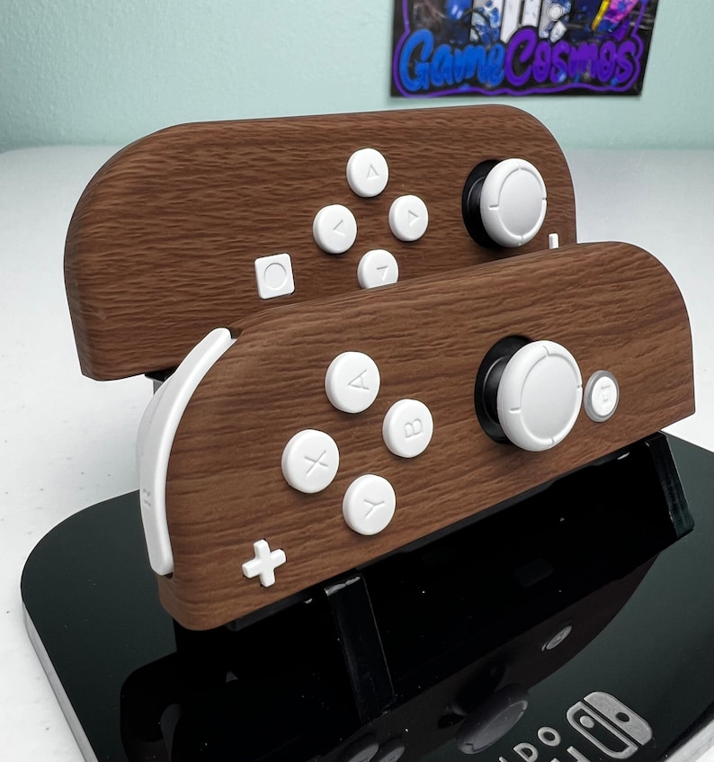 May include: Two wooden Nintendo Switch Joy-Con controllers with white buttons and a black stand. The controllers have a wood grain pattern.