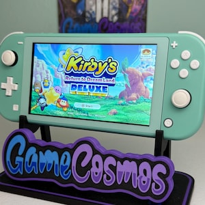 May include: A white ceramic mug with a black handle and the text "But First, Coffee" in a handwritten style. The mug is on a white surface. The mug is approximately 4 inches tall.