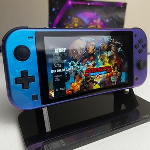 Op de afbeelding: Een blauwe Nintendo Switch-console met een gamecartridge erin. De game is Streets of Rage 4, en het scherm toont het hoofdmenu van de game met opties voor Story, Arcade, Boss Rush, Battle en Join Online Games. De console staat op een zwarte standaard.