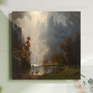 May include: A landscape painting depicting a serene valley with a river, mountains, and trees. The artwork features a dramatic sky with sunlight breaking through clouds. Two deer stand near the water's edge, adding a touch of wildlife to the scene.