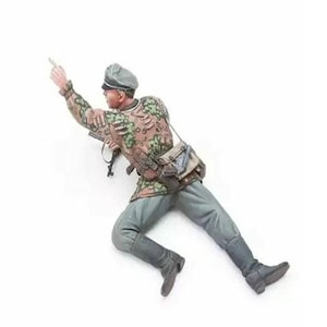 Puede incluir: Figura en miniatura detallada de un soldado con uniforme de camuflaje, señalando con la mano derecha. La figura lleva una gorra gris, pantalones grises y botas negras. Una bandolera cuelga de su hombro. La figura está en posición de carrera.