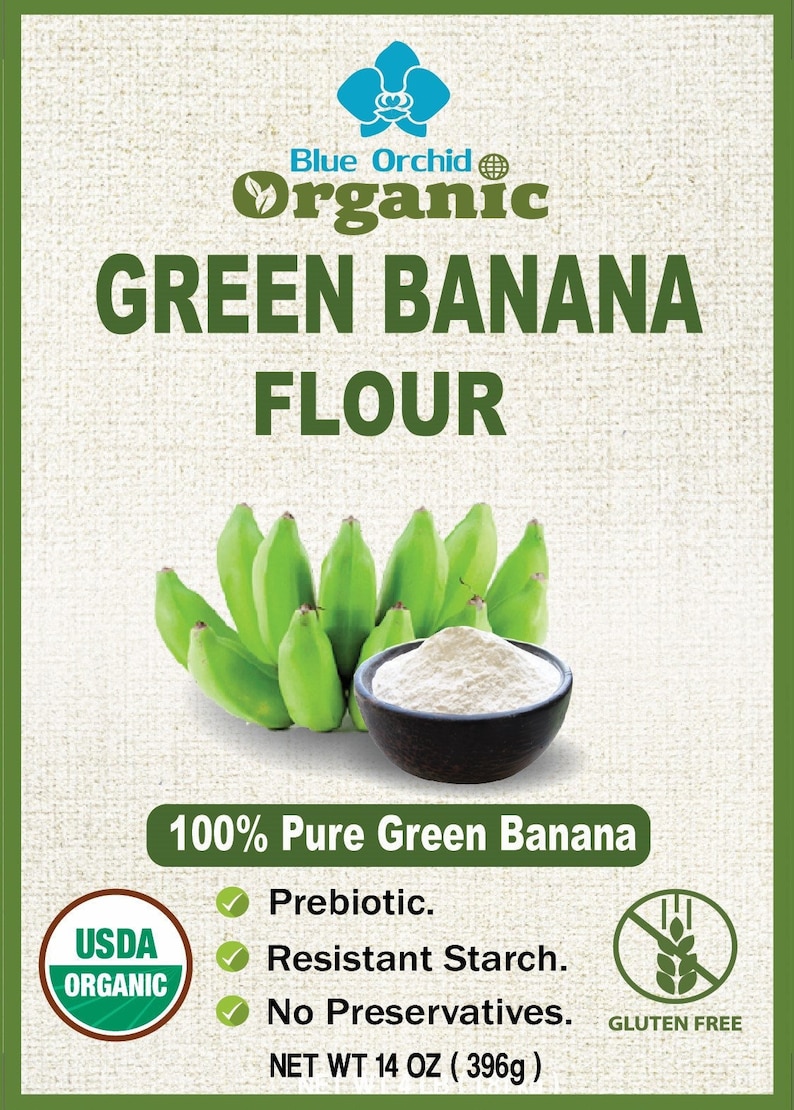 Puede incluir: Una bolsa de harina de pl&aacute;tano verde con un racimo de pl&aacute;tanos verdes y un taz&oacute;n de harina. La bolsa est&aacute; etiquetada como "Blue Orchid Organic Green Banana Flour" y tiene un sello USDA Organic. Tambi&eacute;n dice "100% Pure Green Banana", "Prebi&oacute;tico", "Almid&oacute;n resistente", "Sin conservantes" y "Sin gluten". La bolsa pesa 396 gramos (14 onzas).