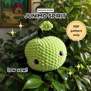 Puede incluir: Un peluche de Junimo Spirit tejido a ganchillo en verde claro con tallo y hoja negros, ojos negros y mejillas rosas. El texto en la imagen dice: MAISON EMIRI, JUNIMO SPIRIT, @maison.emiri, PDF pattern only y low sew! El peluche es redondo y texturizado.