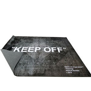 May include: A black and white rug with a vintage pattern and the text "KEEP OFF" in white. The rug is made by IKEA in collaboration with Virgil Abloh and is labeled "Flooring" with the location Almhult, Sweden and the year 2019.