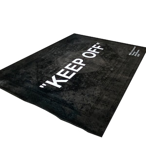 May include: Black and white rug with the text "KEEP OFF" in white lettering. The rug has a distressed, vintage look.