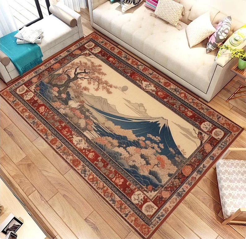 May include: A traditional Japanese-style rug with a detailed illustration of Mount Fuji and cherry blossoms. The rug has a red, blue, and gold border with intricate patterns.