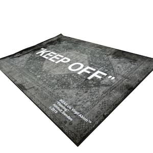 May include: A black and white rug with a vintage pattern and the text "KEEP OFF" in white. The rug is labeled "IKEA&reg; c/o Virgil Abloh&trade;" and "Flooring" with the location "Almhult, Sweden" and the year "c. 2019".