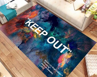 May include: A colorful abstract rug with the text "KEEP OUT" in white. The rug has a blue, yellow, orange, and red color scheme. The text "IKEA® c/o Virgil Abloh™" is in the bottom right corner of the rug.