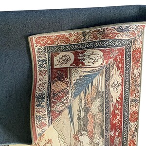May include: A rug with a detailed floral pattern in shades of red, brown, and cream. The rug has a black backing and a fringe border.