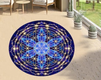 Op de afbeelding: Een rond blauw en gouden mandala-kleed met een levensbloem-ontwerp. Het kleed heeft een donkerblauwe achtergrond met gouden lijnen en een lichtblauw midden.
