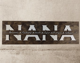May include: A wooden sign with the word "FAMILY" spelled out in silver metal letters. The letters are in the shape of tent silhouettes. Below the word "FAMILY" are the names Brianna, Zachary, Jacob, Tyler, Morgan, and Joshua written in cursive with hearts between each name.