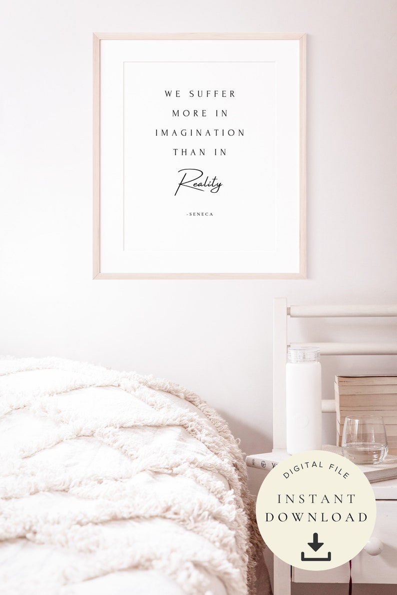 Pu&ograve; includere: Una stampa incorniciata con sfondo bianco e testo nero che recita "We suffer more in imagination than in reality - Seneca". La stampa &egrave; appesa a una parete bianca sopra un letto bianco con una morbida coperta bianca.