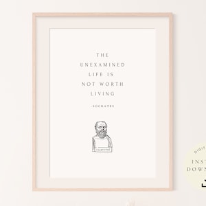 May include: A printable quote by Socrates, "The unexamined life is not worth living." The quote is in black text on a white background with a black and white illustration of Socrates below the quote. The text "Socrates" is below the illustration. The image is framed in a light wood frame.