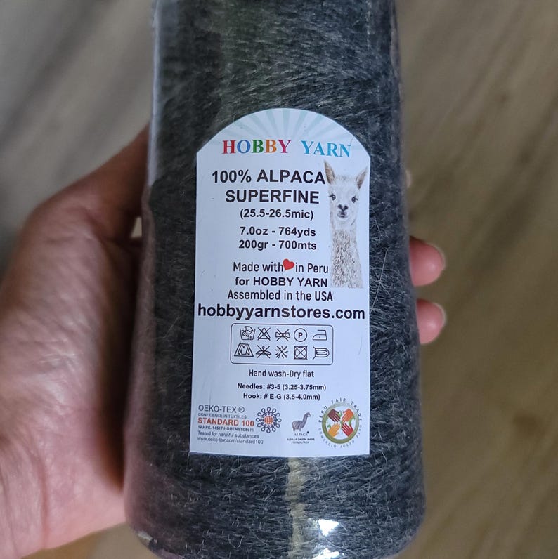 Pode incluir: Um novelo de l&atilde; de alpaca 100% superfina cinza-escura da Hobby Yarn. O r&oacute;tulo especifica 200gr, 700mts, 7.0oz, 764yds e inclui instru&ccedil;&otilde;es de cuidado, tamanho de agulha 3,25-3,75mm e tamanho de agulha de croch&ecirc; 3,5-4,0mm.