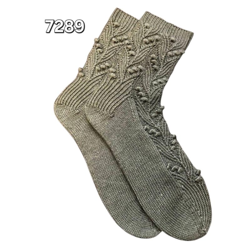 May include: A pair of gray knitted socks with a textured pattern. The socks feature a ribbed cuff and a decorative design along the leg. The number "7289" is printed in the upper left corner.