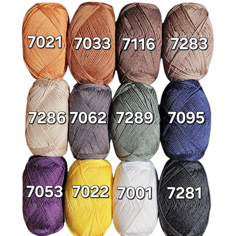 May include: A collection of twelve yarn skeins in various colors, including orange, brown, gray, green, blue, purple, yellow, white, and black. Each skein is labeled with a four-digit number. The yarn is tightly wound, showing the texture of the fibers.