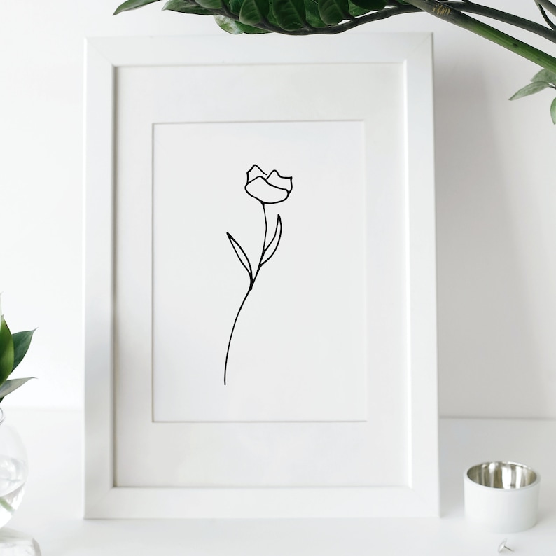 Simple line drawn of a rose in a picture frame.