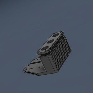 May include: A dark gray L-shaped mechanical component featuring a honeycomb-patterned side panel and a top plate with three circular openings. The base includes a flat section with multiple small circular mounting holes and text on the edge.