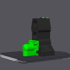 May include: A black and green 3D printed object. The object is made up of two parts, a larger black base and a smaller green top. The green top has a rounded shape and appears to be a nozzle or spout.