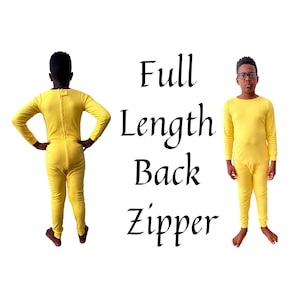May include: Yellow full-length pajamas with a back zipper. The pajamas are shown on two people, one facing away and one facing forward. The text "Full Length Back Zipper" is displayed in black cursive font.