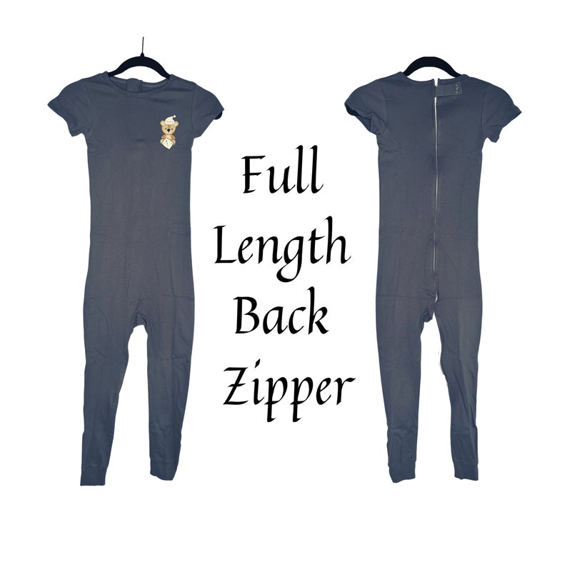 May include: A gray short-sleeved jumpsuit with a full-length back zipper. The jumpsuit has a small embroidered bear on the front.