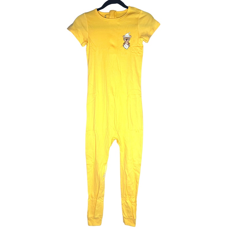 May include: A yellow one-piece jumpsuit with short sleeves and a small embroidered bear on the chest.