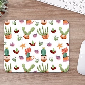 May include: A white mouse pad with a repeating pattern of potted cacti and succulents. The cacti and succulents are in various colors, including green, orange, pink, and yellow. The pattern is on a white background.