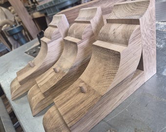 A pair of chunky oak and pine shelving brackets