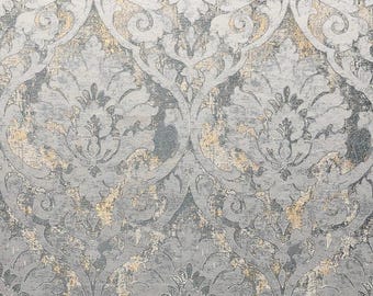 May include: A wallpaper featuring a repeating damask pattern in shades of gray, silver, and muted gold. The design consists of intricate, symmetrical floral and scroll motifs with a distressed, textured appearance across the entire surface.