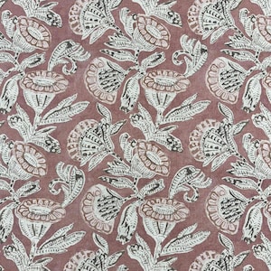 May include: A pink fabric with a white floral pattern. The flowers are stylized and have a black outline. The fabric has a vintage feel.