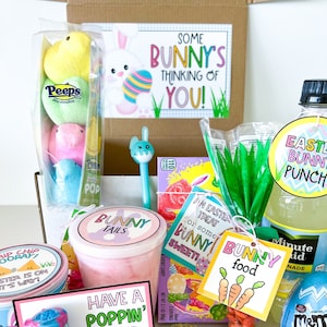 May include: A set of three ceramic mugs with a speckled, matte finish. Each mug features a different color: light blue, cream, and gray. The mugs have a simple, modern design with a rounded shape and a comfortable handle.