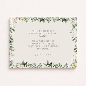 Peut inclure: Une carte rectangulaire avec un fond beige clair et une bordure florale de fleurs blanches et de feuilles vertes. Le texte se lit comme suit : « Le Seigneur est mon berger, je ne manquerai de rien. Il me fait reposer dans de verts pâturages. Il restaure mon âme. Psaume 23:1-3."