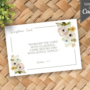 May include: A white card with a floral design in the corner. The card has a black border and the text "Scripture Card" at the top. The text "WORSHIP THE LORD WITH GLADNESS; COME BEFORE HIM WITH JOYFUL SONGS." is in black text. The text "Psalms 100:2" is in black text at the bottom of the card.
