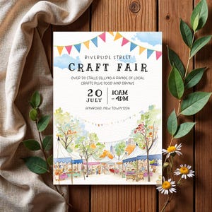 May include: A poster advertising a craft fair, with the text "Riverside Street Craft Fair" at the top. The poster includes the date, time, and location of the event. The image features colorful bunting and a watercolor illustration of craft stalls.