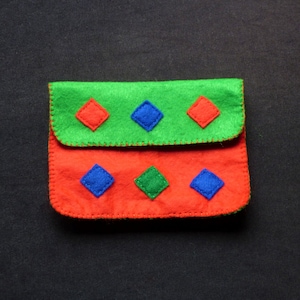 May include: A small red and green felt pouch with blue and green felt squares sewn on the front.