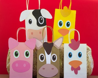 May include: Five colorful paper gift bags with animal faces. The bags are decorated with a cow, a chicken, a pig, a horse, and a chick. The bags are sitting on a bed of straw.