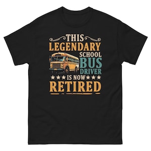 Puede incluir: Camiseta negra con un gráfico de un autobús escolar amarillo y el texto "This Legendary School Bus Driver Is Now Retired".