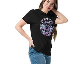 May include: Black t-shirt with a graphic design of a black cat holding a potion bottle, framed by crystals, moons, and leaves. The design uses pastel colours, including purple, blue, and pink. The shirt is made of a soft material.