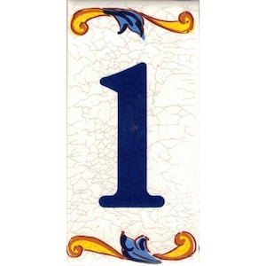 May include: A white ceramic tile with a blue number "1" and yellow and blue floral designs.