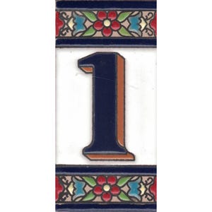 May include: Ceramic tile displaying the number 1 in navy blue with an orange outline, set on a white background. The tile is framed by a decorative border with floral and geometric patterns in red, blue, green, and yellow.