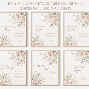 May include: A set of six framed signs for a baby shower, featuring floral and butterfly illustrations. The signs include text such as "Mom-osa Bar," "Bloom Bar," "Guest Book," "Thank You," "Cards and Gifts," and "Custom Sign."