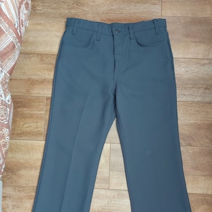 May include: A pair of dark grey, straight-leg trousers with a button fly and belt loops.