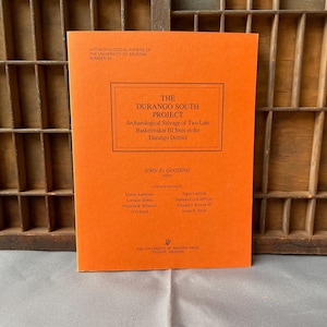 May include: An orange book titled "The Durango South Project" with black text. The book is part of the Anthropological Papers of the University of Arizona series. The book's cover includes the names of contributors and the University's press.