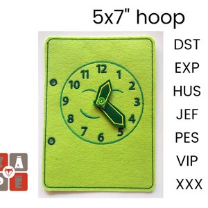 Op de afbeelding: Een groene viltklok met zwarte cijfers en een groene viltwijzer. De klok bevindt zich op een groene vilt achtergrond met een 12,7x17,8 cm hoepel. De tekst "DST, EXP, HUS, JEF, PES, VIP, XXX" staat aan de rechterkant van de afbeelding.