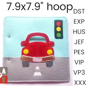 May include: A felt toy car with a red body, yellow headlights, and a grey road. The car is in front of a traffic light with red, yellow, and green lights. The toy is 7.9 inches by 7.9 inches.