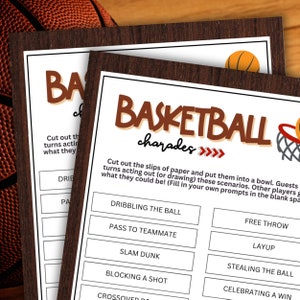 May include: Basketball charades game cards with a brown wooden frame. The cards have a white background with brown text that reads "Basketball charades". The cards include prompts like "Dribbling the ball" and "Free throw". A basketball is visible in the background.
