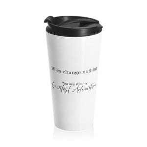 May include: White travel mug with a black lid. The mug features the text "Miles change nothing, You are still my Greatest Adventure" in black script. A travel mug is a great gift.