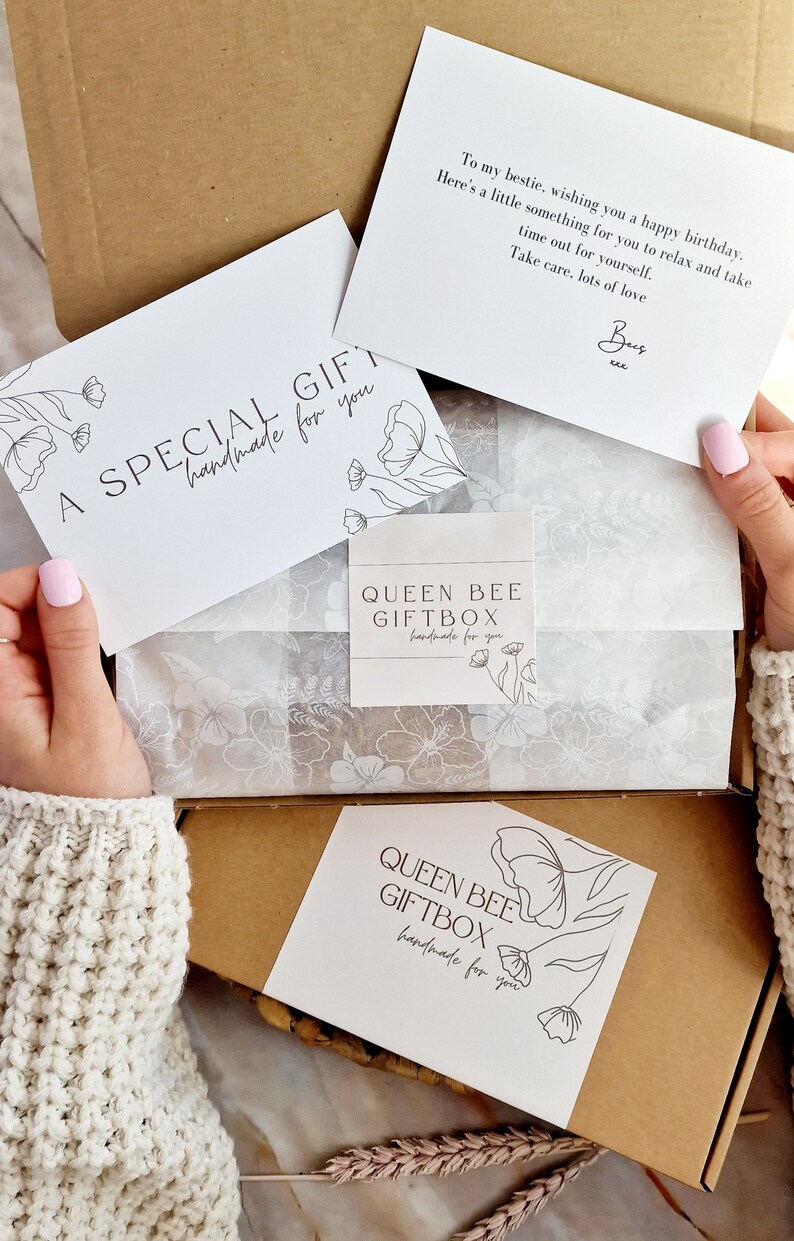 May include: A brown cardboard box with a white tissue paper lining. The box contains a white card with the text "A SPECIAL GIFT handmade for you" and a white card with the text "QUEEN BEE GIFTBOX handmade for you".