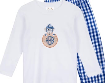 May include: White long-sleeved pajama top with an embroidered design of a baseball player on a baseball. The baseball has the initials HBB in a blue font. The pajama pants are blue and white checkered.